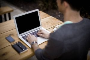 Person in front of laptop blogging